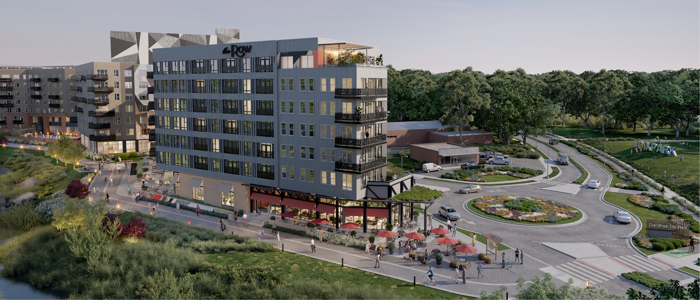 Arial view of the Row next to Dix Park bottom level shops, outdoor seating, lit up walk paths and a roundabout driveway